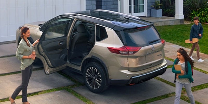2025 Nissan Rogue in driveway with backdoor open