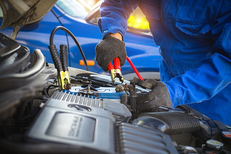 man servicing car battery